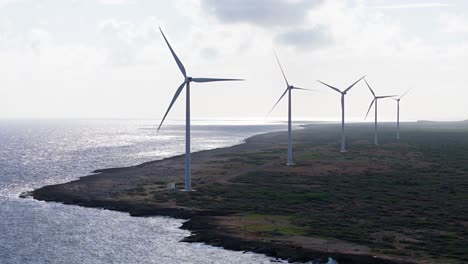 Row-of-wind-turbines-spin-on-north-volcanic-rocky-coast-of-tropical-island