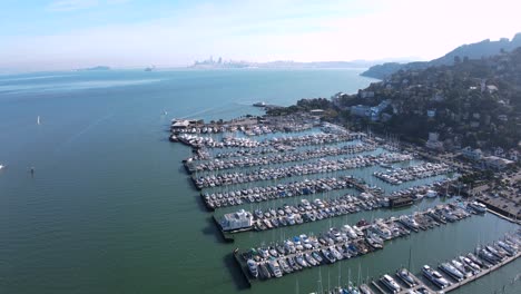 Die-Drohne-Erfasst-Den-Geschäftigen-Yachthafen-Von-Sausalito-Vor-Der-Atemberaubenden-Kulisse-Der-Ikonischen-Stadtlandschaft-Von-San-Francisco-Und-Der-Bay-Bridge