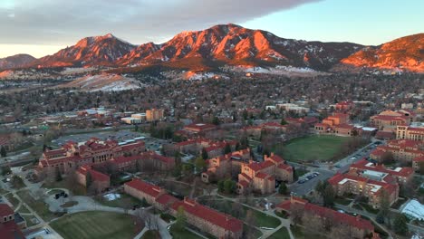 Hermoso-Amanecer-Aéreo-De-Drones-Sobre-La-Roca-De-La-Universidad-De-Colorado-Con-Montañas-Al-Pie-De-Las-Planchas-Al-Fondo-En-Una-Mañana-De-Invierno