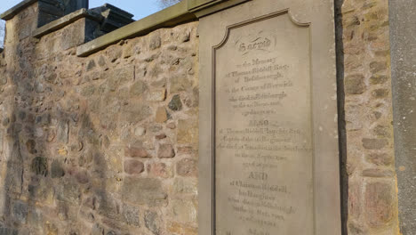 Pan-across-old-headstone-in-Greyfriars-Kirkyard-Cemetery-in-Edinburgh,-Scotland