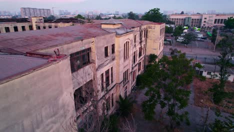 Maternity-Barros-Luco-Hospital-Abandoned-Ruined-Building-Aerial-Drone-Panorama-in-Santiago,-Chile-at-Sunset-Dusk