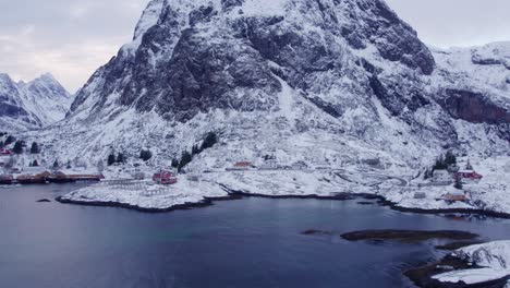 Hohe-Felsige-Berge,-Die-über-Den-Verstreuten-Häusern-In-Der-Bucht-Der-Lofoten-Inseln-In-Norwegen-Aufragen