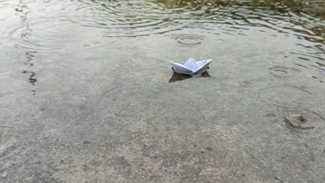 paper-boat-on-a-puddle-of-water-during-the-rain
