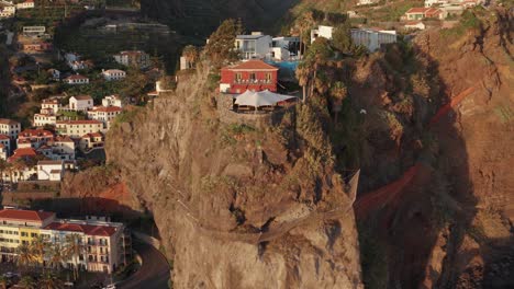Scenic-coastal-city-with-buildings-on-top-of-a-mountain-range-and-in-valley-during-sunset-in-Ponta-Do-Sol,-Madeira,-Portugal