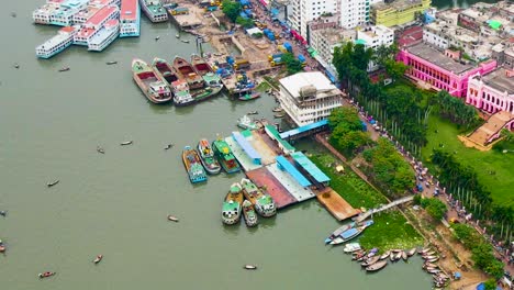 Docked-Boats-Along-Buriganga-River-With-Ahsan-Manzil-Museum-In-Dhaka,-Bangladesh