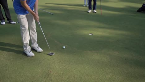 closeup-to-the-ball,-golfer-hits-the-ball-with-the-stick-into-the-hole
