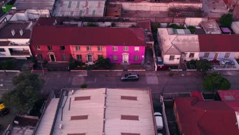 Aerial-traveling-of-a-street-with-identical-houses-side-by-side,-bright-colors-in-a-quiet-neighborhood