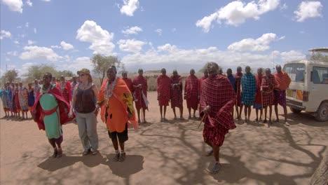 Touristen-Tanzen-Und-Springen-Mit-Menschen-Des-Afrikanischen-Massai-Stammes-In-Roter-Ethnischer-Kleidung