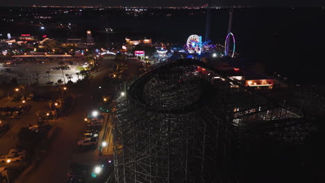 Aerial-view-around-the-rollercoaster-at-the-Kemah-Boardwalk,-night-in-Texas,-USA
