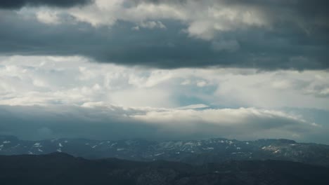 Dichte,-Schwere,-Weiße-Wolken,-Vom-Starken-Wind-Getragen,-Rollen-über-Die-Waldbedeckte-Küste-Des-Hardangerfjords