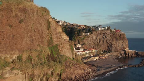 Calm-serene-coastal-city-by-the-ocean-slowly-revealed-behind-mountain-during-sunset-in-Ponta-Do-Sol,-Madeira,-Portugal