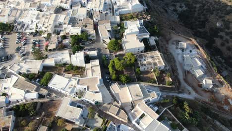 Drohnenansicht-In-Griechenland,-Draufsicht-über-Eine-Griechische-Stadt-Mit-Weißen-Häusern-Und-Weißen-Dächern-Auf-Einem-Braunen-Berg