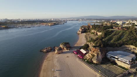 Wundervoller-Strand-Praia-Grande-In-Ferragudo,-Portugal,-Luftaufnahme,-Goldene-Stunde