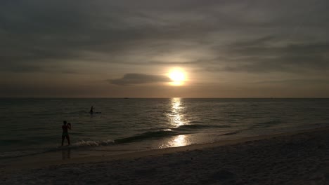 Time-Lapse-of-the-Sun-setting-over-the-sea-on-a-stunning-beach-and-sand-in-Naples,-Florida