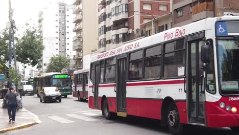 Rot-weißer-Bus-Fährt-Entlang-Der-Avenue-In-Der-Stadt-Buenos-Aires,-Argentinien,-Omnibus,-öffentliche-Verkehrsmittel