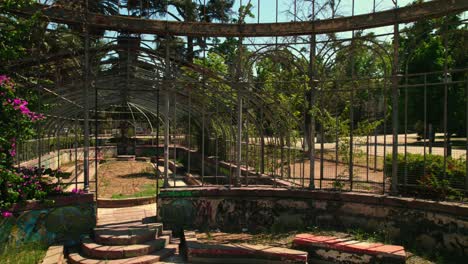 Panoramic-Shot-inside-Greenhouse-of-the-Art-Nouveau-Villa-of-Santiago-de-Chile,-Green-Garden-with-Flowers-and-Skyline