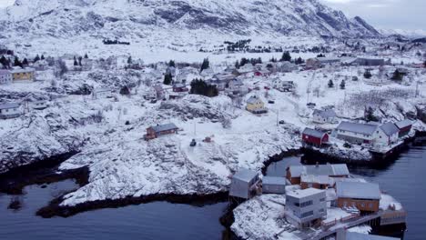 Aerial-view-of-the-peaceful-and-picturesque-snow-covered-landscape-of-Lofoten-with-scattered-buildings-on-the-coast