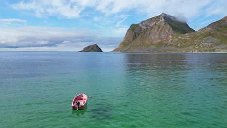 Boot-Schwimmt-Im-Sommer-Im-Arktischen-Meer-Am-Strand-Von-Haukland,-Lofoten,-Norwegen---4K-Luftaufnahme