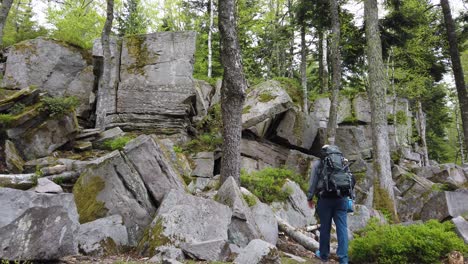 Male-hiker-arriving-at-the-rock-formation-named-Volzemer-Steine-while-hiking-the-popular-long-distance-trail-Westweg-through-the-Black-Forest-in-southern-Germany