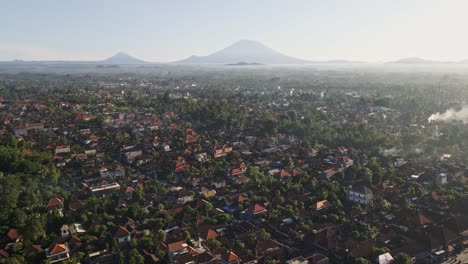 Establishing-scene-of-downtown-Ubud-in-early-morning-with-busy-traffic-and-fire-in-Bali,-Indonesia