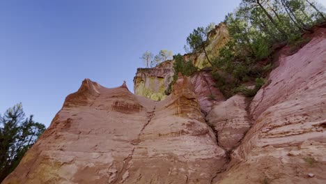 Rocas-Ocres-Con-Diferentes-Capas-De-Color-A-La-Luz-Del-Atardecer-Con-Algunos-árboles-En-Francia-Conservación-De-La-Naturaleza