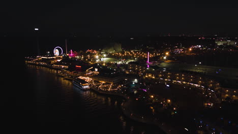 Aerial-view-around-the-illuminated-Kemah-Boardwalk-park,-night-in-Texas,-USA