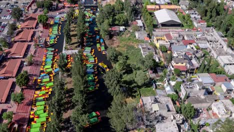 Aerial-view-of-colorful-traditional-boats-on-a-canal,-offering-a-vibrant-and-lively-atmosphere-in-Xochimilco-Mexico