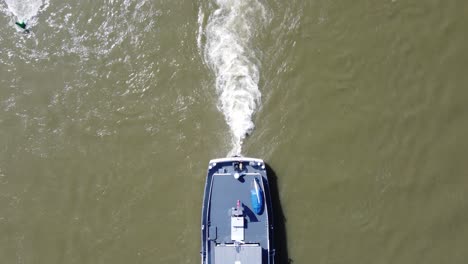Ship-Stern-and-propulsion-wake-of-Barge-navigating-upstream,-Aerial