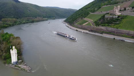 Barge-hotel-cruiser-navigating-on-River-Rhine-by-german-castles,-Aerial