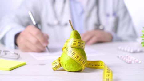 Obst-Als-Gesundes-Ernährungskonzept,-Arzt-Macht-Sich-Notizen,-Birne-Und-Maßband
