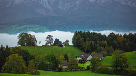 Low-clouds-in-a-valley-by-an-Austrian-village-in-autumn---time-lapse