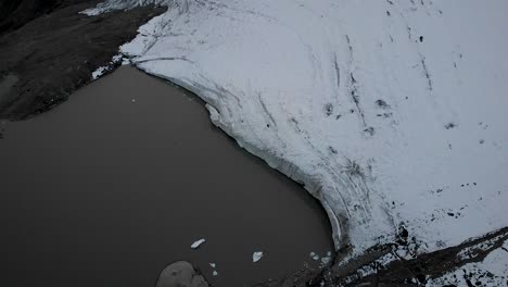 Luftüberflug-über-Den-Gletschersee-Und-Das-Eis-Des-Claridenfirn-Gletschers-In-Uri,-Schweiz,-Am-Ende-Eines-Tages-Mit-Blick-Von-Den-Im-Wasser-Schwimmenden-Eisbergen-Auf-Die-Alpengipfel