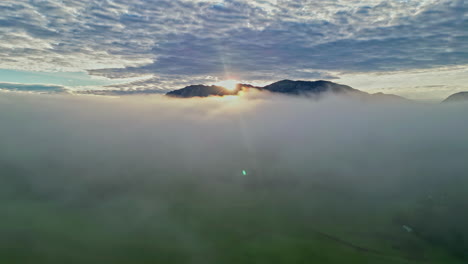 Sonnenaufgang-über-Berggipfeln-Beim-Flug-über-Den-Wolken,-Aber-Unterhalb-Der-Zirrocumulusschicht-Der-Atmosphäre