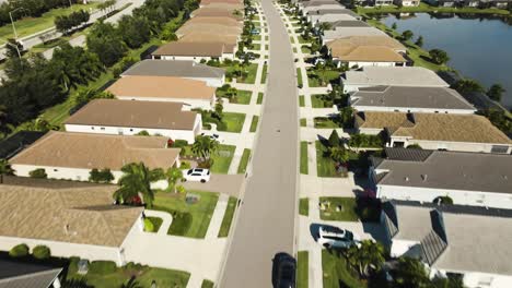Aerial-of-a-sunny-suburban-neighborhood-in-tropical-climate-going-down-the-road