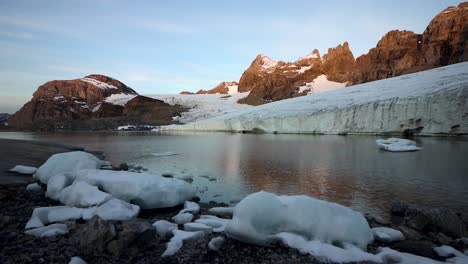 Tranquila-Escena-Matutina-En-El-Lago-Glacial-Junto-Al-Glaciar-Claridenfirn-En-Uri,-Suiza,-Con-El-Brillo-Alpino-De-Los-Picos-Alpinos-Reflejados-Y-Los-Icebergs-En-La-Costa