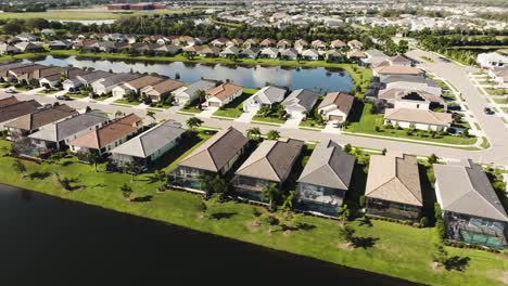 Aerial-of-a-sunny-suburban-neighborhood-in-tropical-climate-circling-the-lake