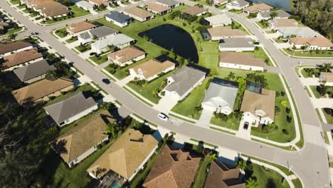 Aerial-of-a-sunny-suburban-neighborhood-in-tropical-climate-over-palm-trees-and-single-homes