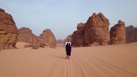 Male-Tourist-Walking-Near-Rock-Formations-At-Sunset-In-Tassili-n'Ajjer-National-Park-In-Algeria