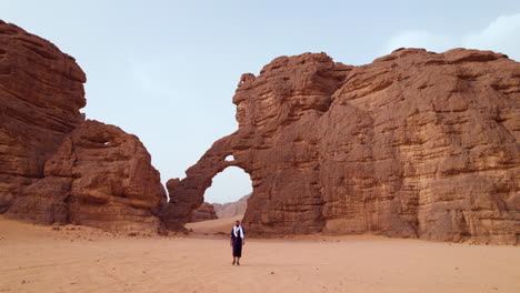 Traveling-Nomad-Backdropped-By-Elephant-shaped-Rock-Formation-At-Sunrise