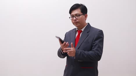Asian-businessman-standing-while-talking-on-the-phone