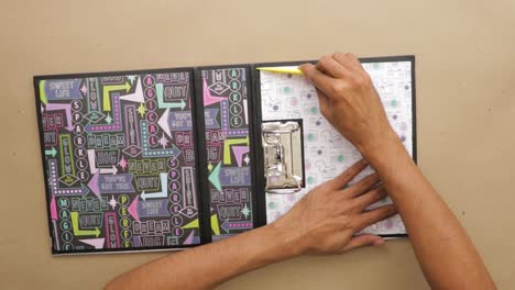 Using-bone-folder-to-smooth-the-inner-cover-of-ring-binder-scrapbook