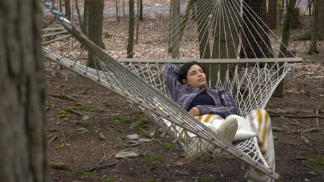 Daydreaming-Puerto-Rican-female-swinging-in-woodland-forest-hammock-carefree-lifestyle