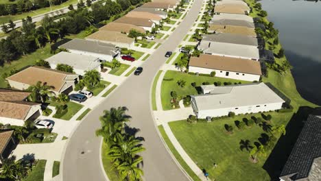 Aerial-of-a-car-driving-in-a-sunny-suburban-neighborhood-in-tropical-climate
