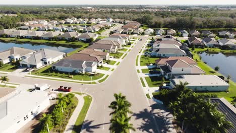 Aerial-of-a-sunny-suburban-neighborhood-in-tropical-climate-entering-from-road