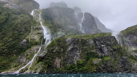 Stürmischer-Wind-Stört-Den-Wasserfall,-Der-Die-Steilen-Klippen-Des-Milford-Sound-Hinunterfließt