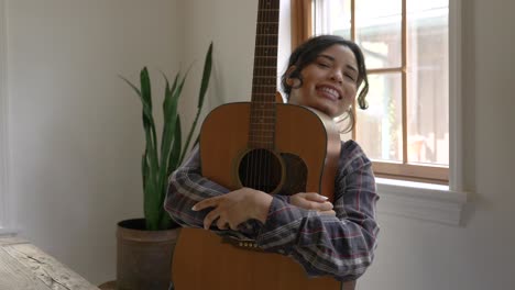 Fröhliches-Lächelndes-Puerto-ricanisches-Mädchen,-Das-Die-Akustikgitarre-In-Freudiger-Umarmung-Umarmt