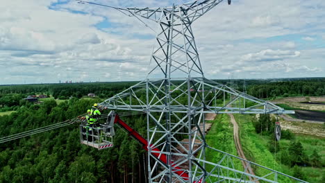 Workers-On-Boom-Lift-During-Installation-Of-Overhead-Powerlines-On-Transmission-Tower