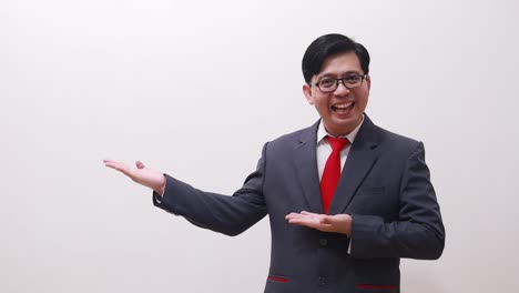 Happy-asian-businessman-standing-while-presenting-sideways