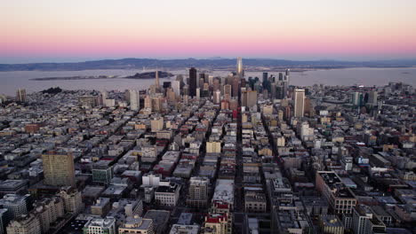 Aerial-view-tilting-over-the-cityscape-of-San-Francisco,-pink-dawn-in-CA,-USA