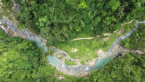 People-trekking-trail-along-creek-in-lush-green-jungle,-Cebu